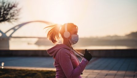 woman exercising outside with a mask on